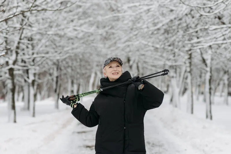 A resident with walking poles on the snowy path