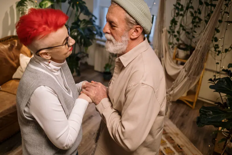 A couple holding hands in their room