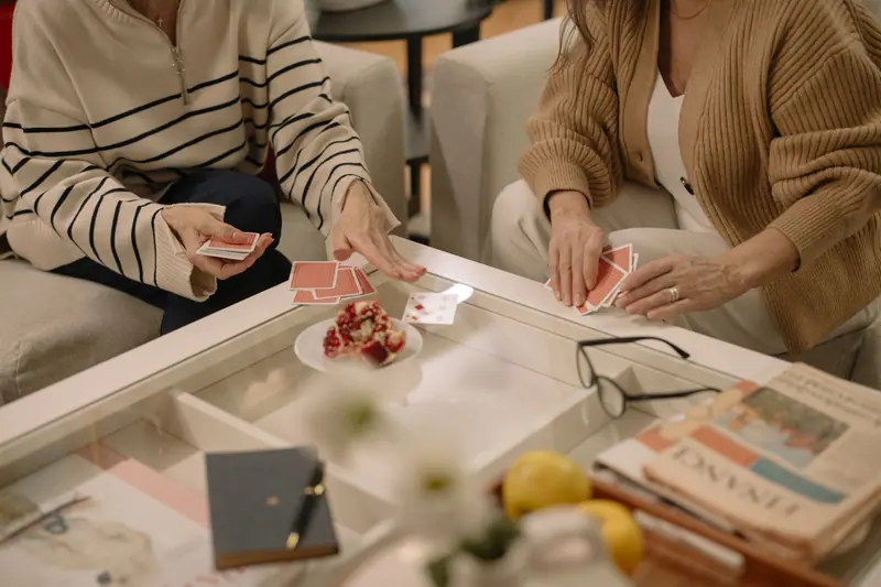 Two residents playing cards over afternoon snacks