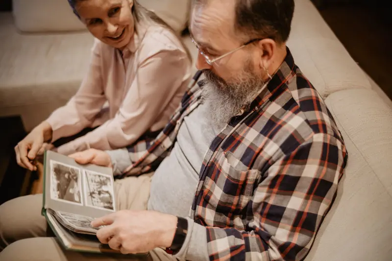 A resident and his daughter laughing over the family album