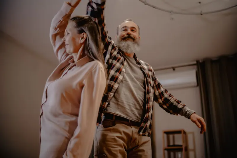 A couple dancing in the living room after supper