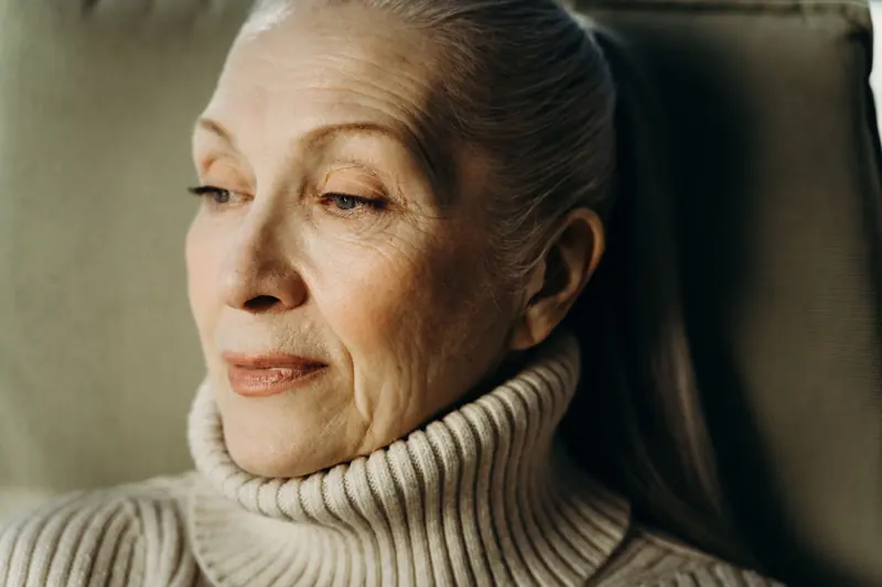 A resident in a turtleneck in soft window light