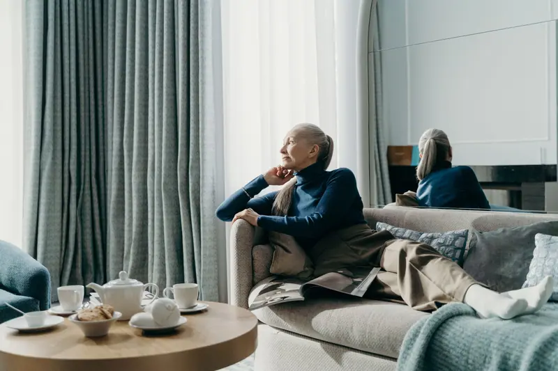 Two residents resting on the sofa beside the tea tray