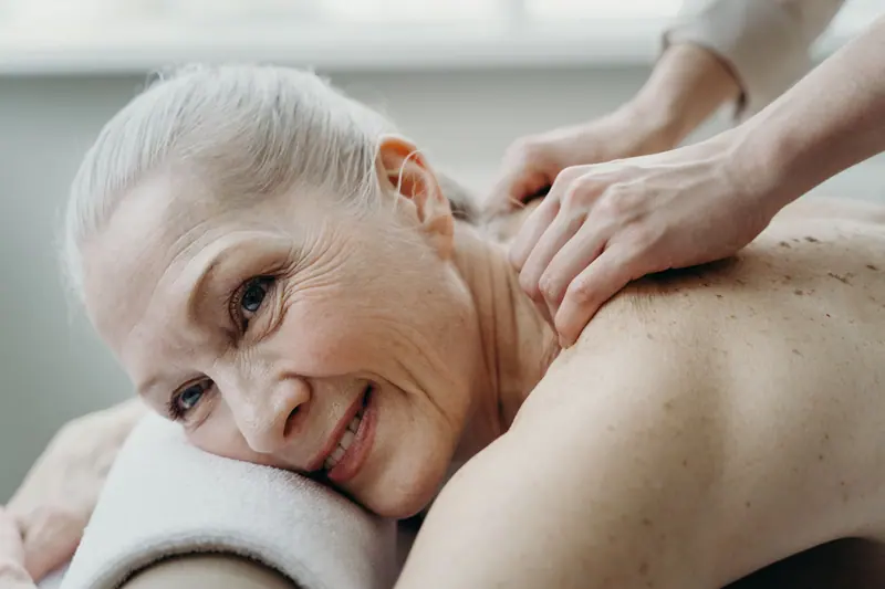 A resident smiling during a shoulder massage
