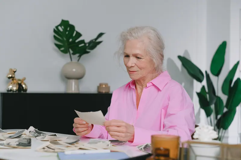 A resident with old photographs spread across the table