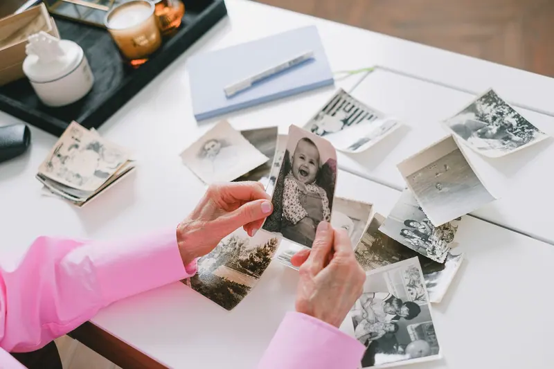 A resident's hands holding an old baby picture
