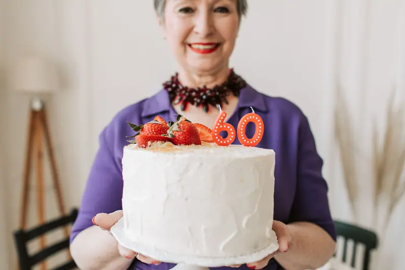 A resident holding her 80th birthday cake