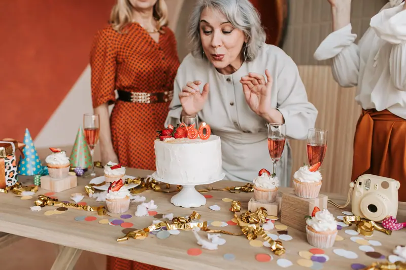 A resident blowing out the candles on her cake