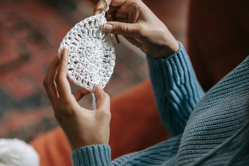 A resident's hands holding a crocheted doily