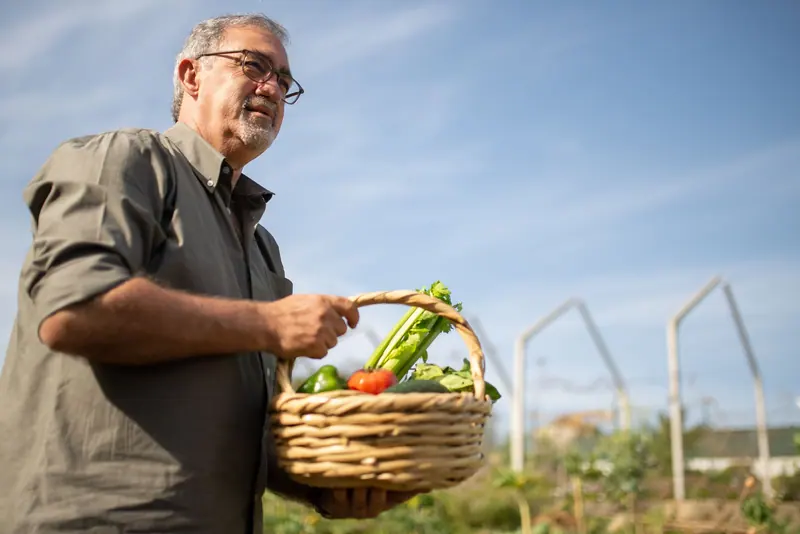 A resident carrying the morning's harvest in a wicker basket