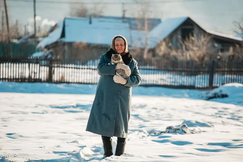 A resident in front of the farmhouse on a snowy day