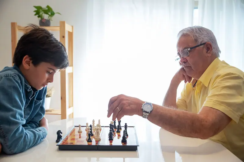 A resident playing chess with a young visitor