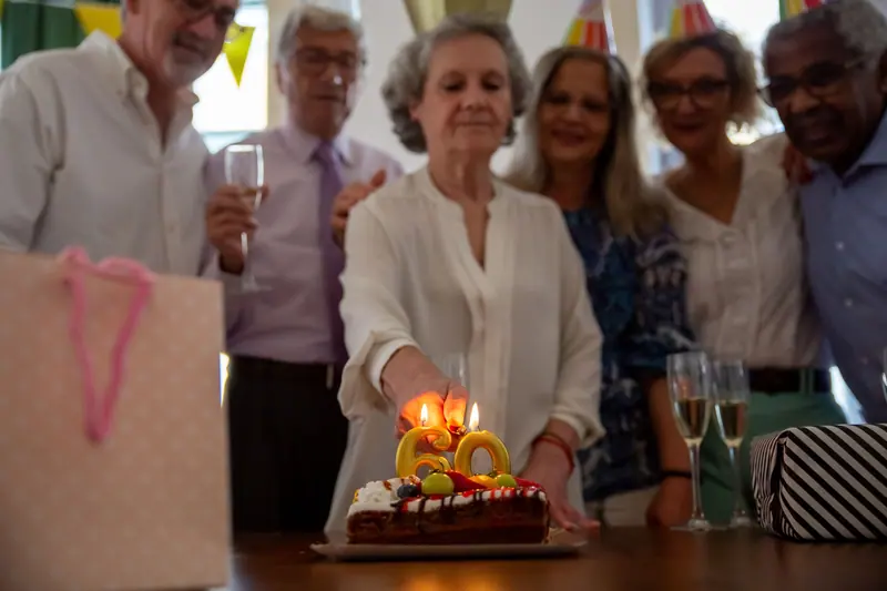 Friends gathered around a resident's birthday cake