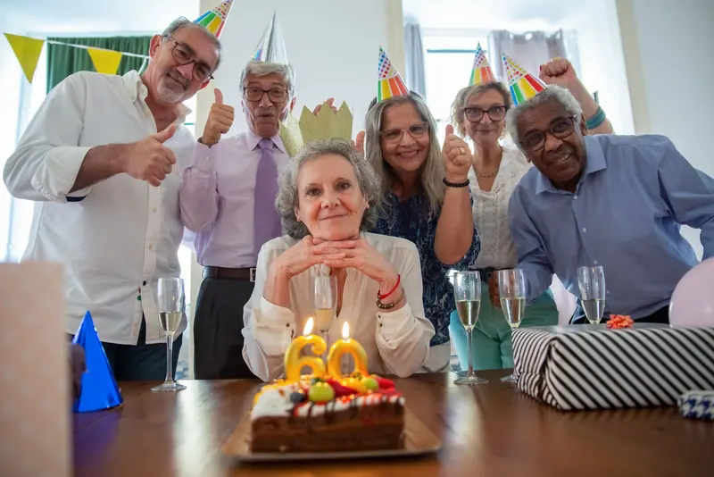 A resident beaming behind her eightieth birthday cake