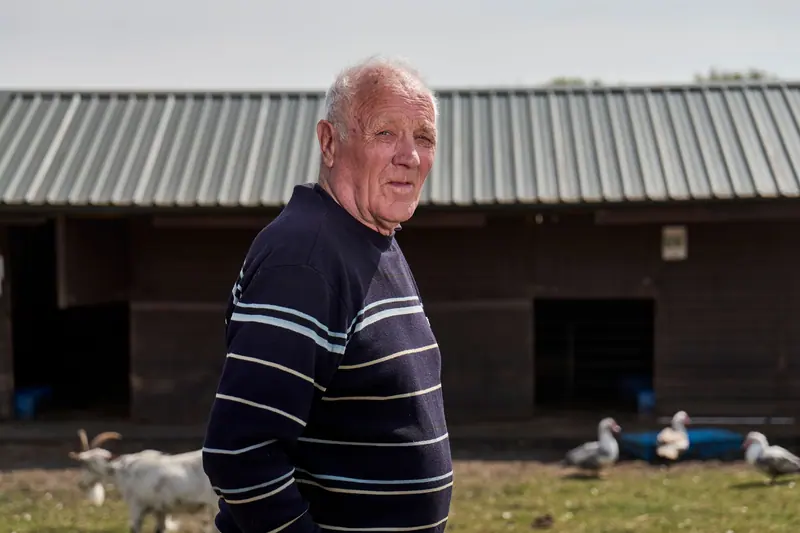 A smiling resident in front of the old barn
