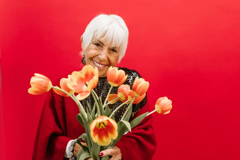 A resident holding tulips she brought in for still-life day
