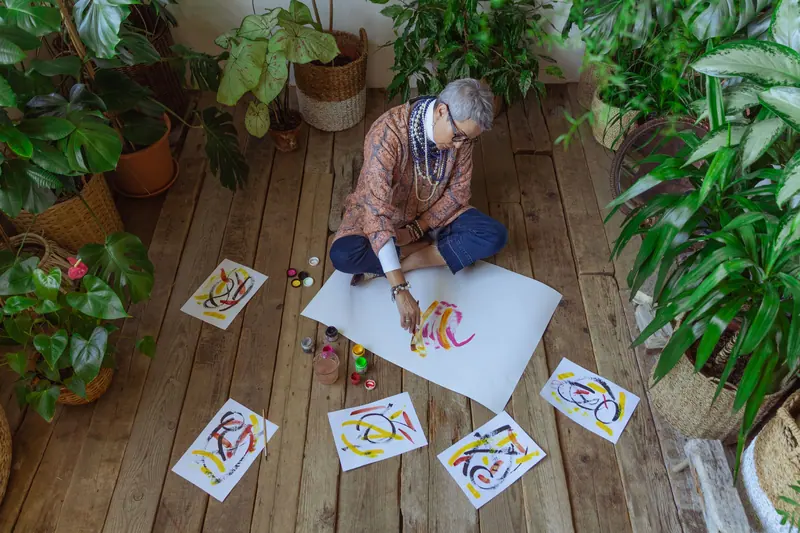 Finished paintings drying on the studio floor around a resident