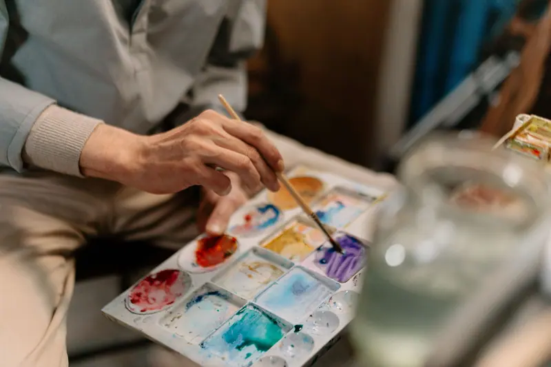 A resident mixing blues in the watercolor tray