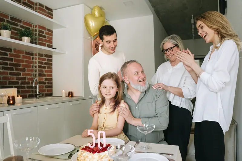 A family celebrating a resident's birthday in the kitchen