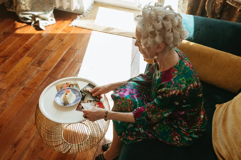 A resident in curlers looking through photos in the sunlit living room