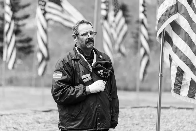 A veteran with his hand over his heart among the flags