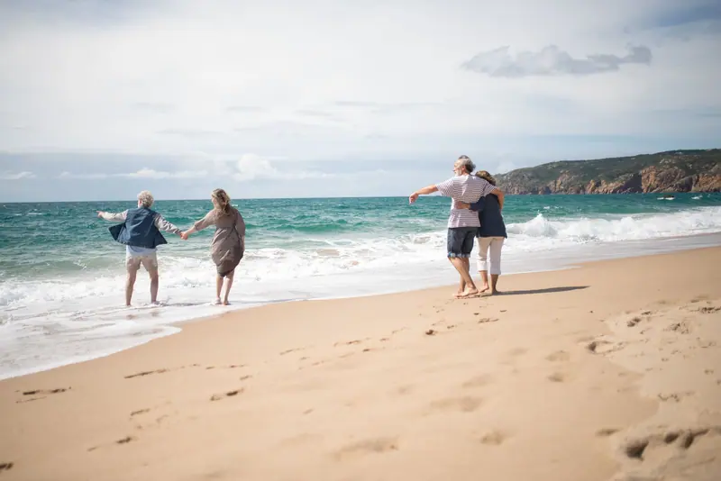 Couples walking along the surf