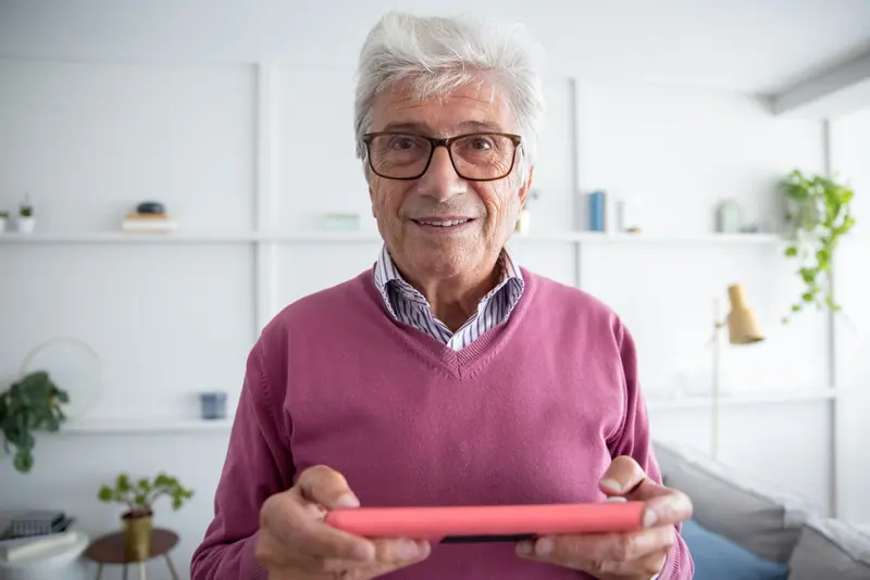 A resident smiling with his tablet