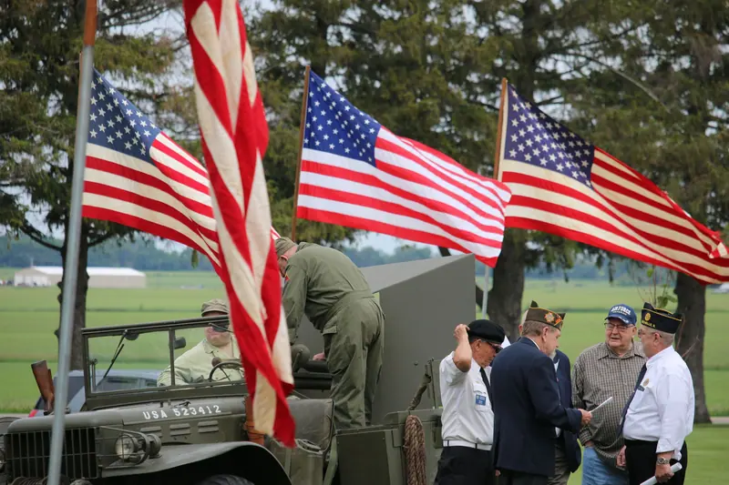 Veterans gathered by an old Army truck at a parade