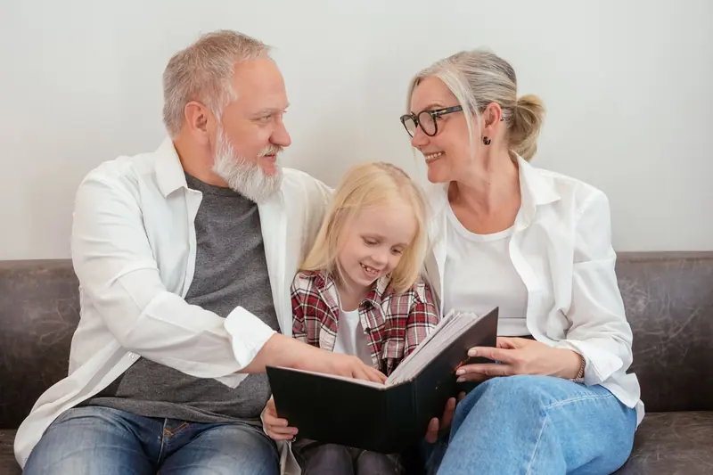 Residents paging through a photo album with a visiting granddaughter