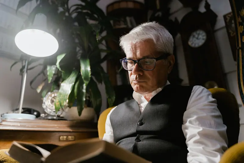 A resident reading by lamplight