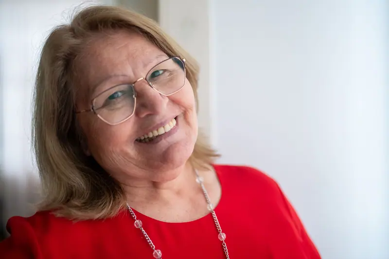 A resident in a red blouse, smiling