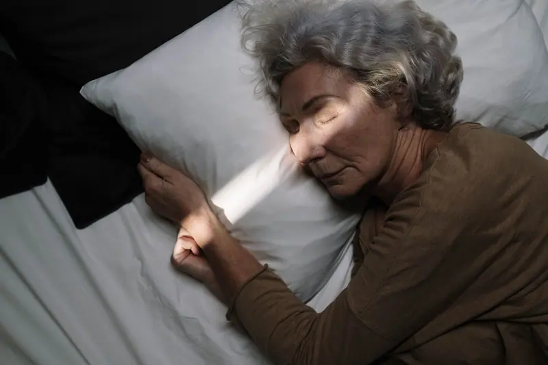 A resident asleep in a stripe of evening light