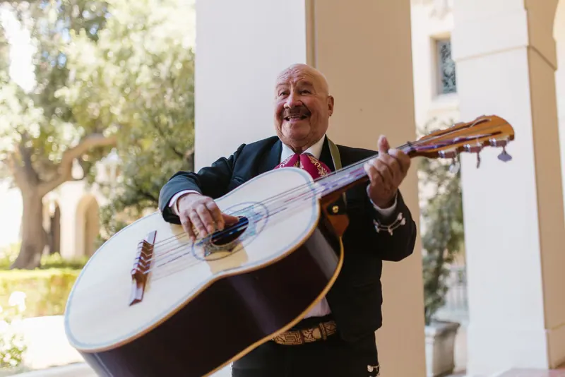 A resident in a suit playing guitar on the porch