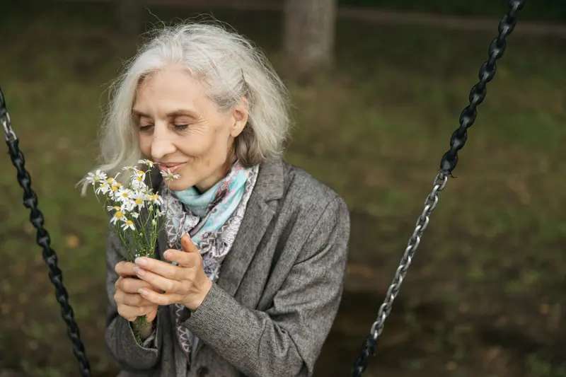 A resident smelling daisies on the courtyard swing