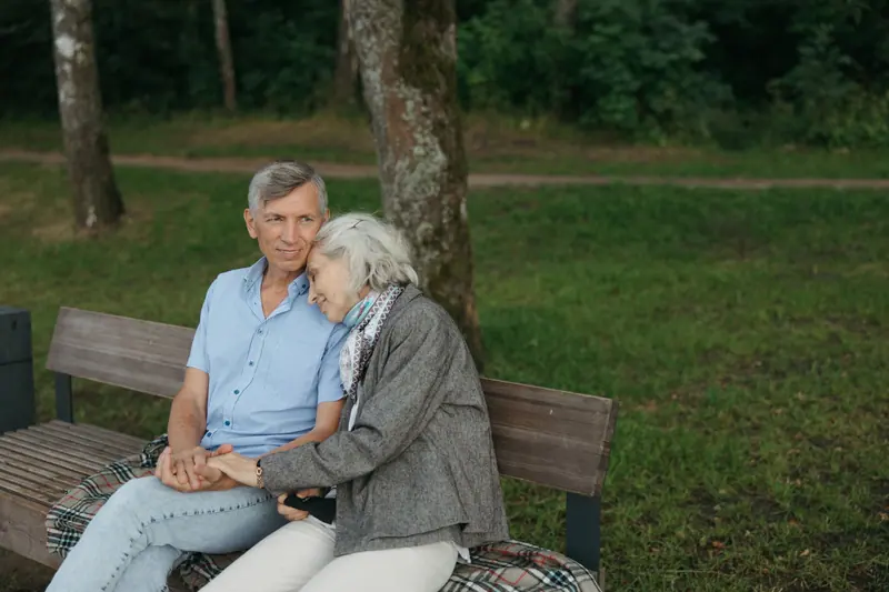 A married couple on a bench in the courtyard