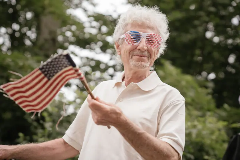 A resident in star-shaped glasses waving a flag