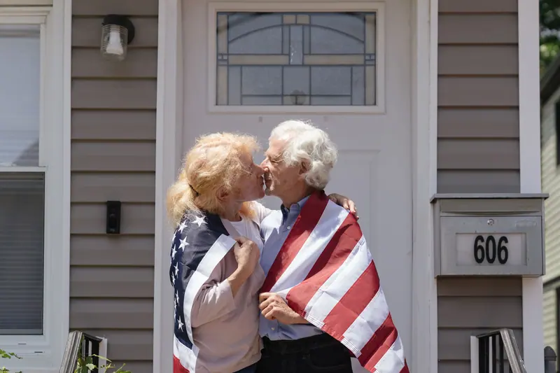 A couple wrapped in the flag on their front step