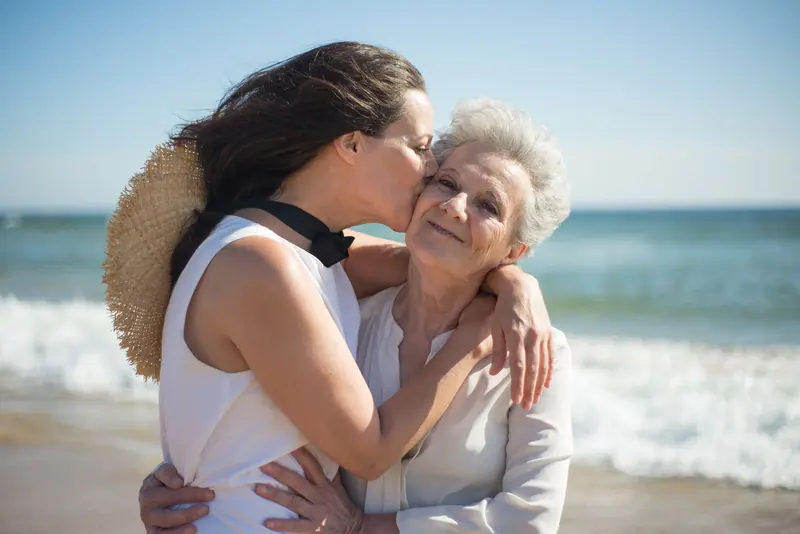 A resident and her daughter embracing at an opening reception