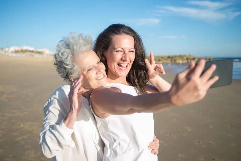 A daughter taking a selfie with her mother on a family trip