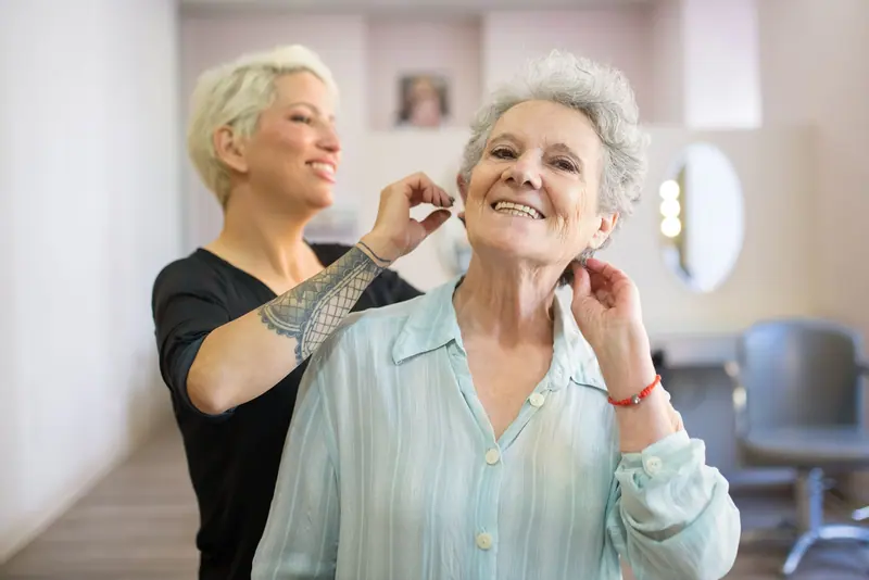 A resident laughing with the stylist on beauty shop day