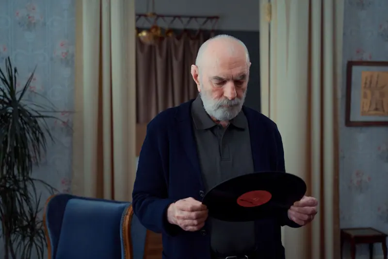 A resident holding a favorite record, deciding what to play next
