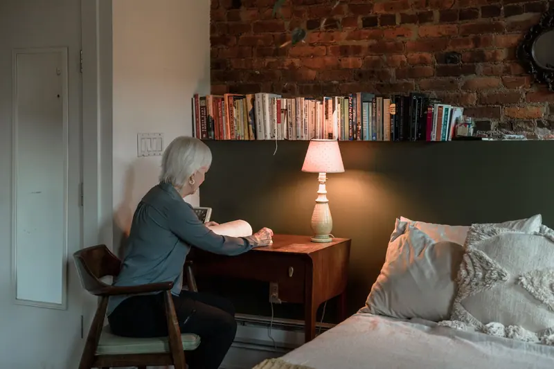 A resident writing at her desk beside the lamp