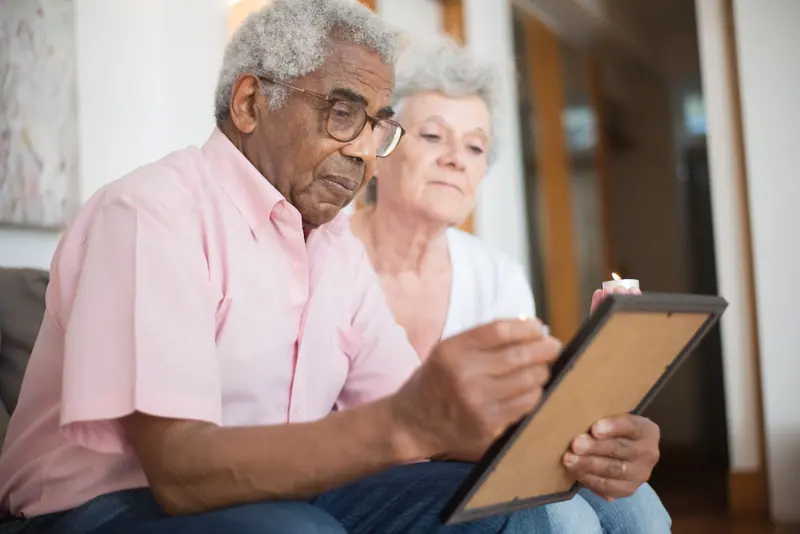 A resident and his wife holding up a framed photograph