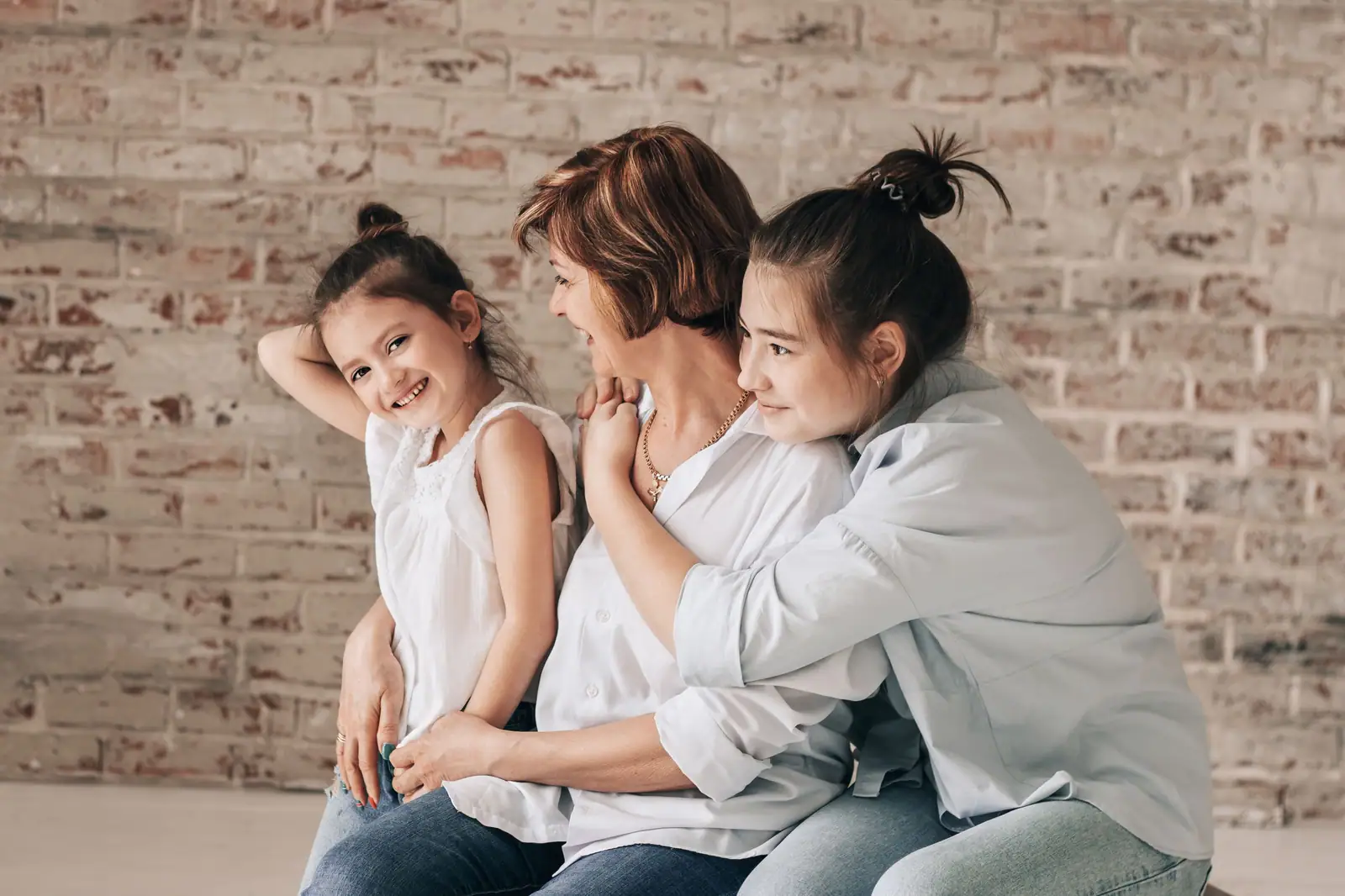 A resident and her granddaughters laughing together on visiting day