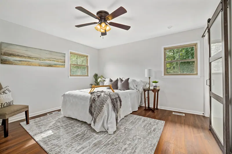 Tranquil modern bedroom with cozy white bedding and classic wood accents.