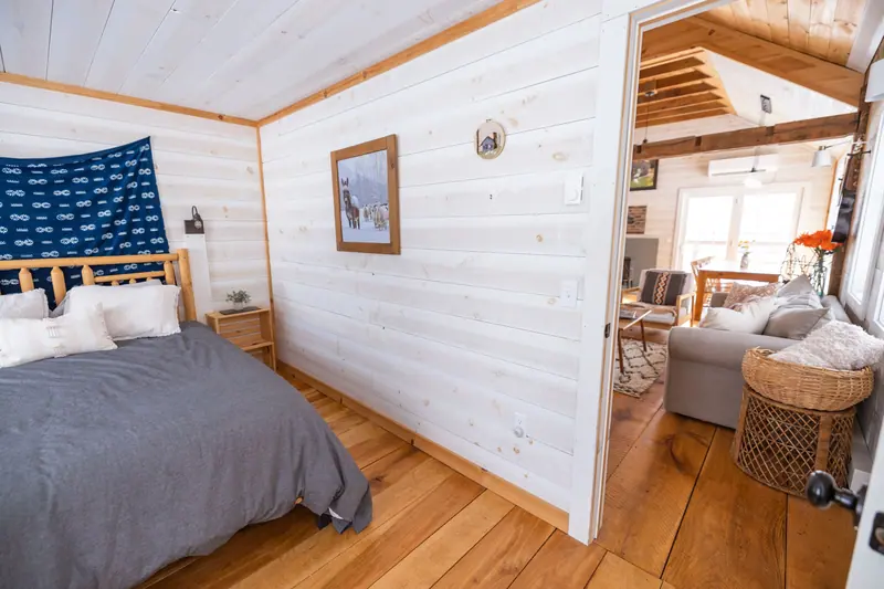 Charming rustic interior showcasing a cozy bedroom with a view into an open living area.