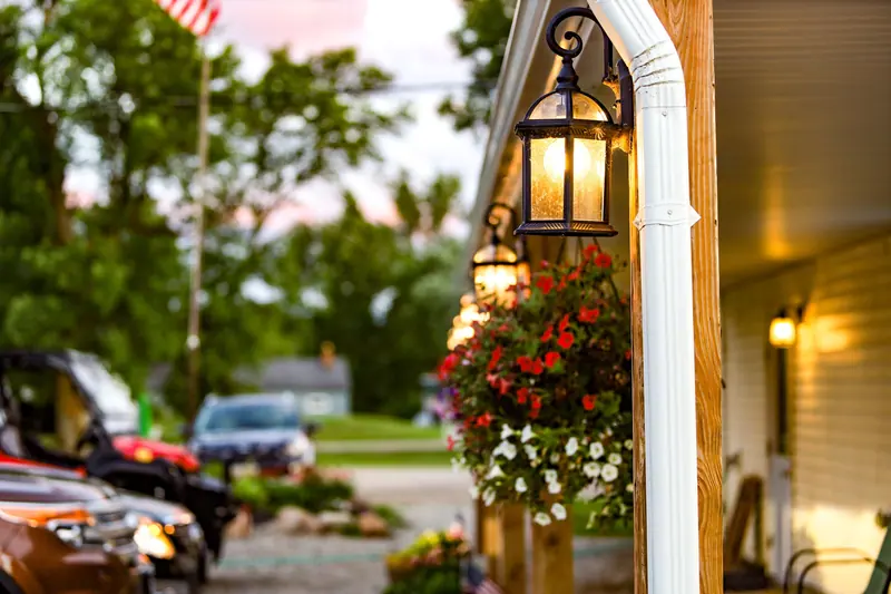 A cottage porch with hanging baskets at dusk