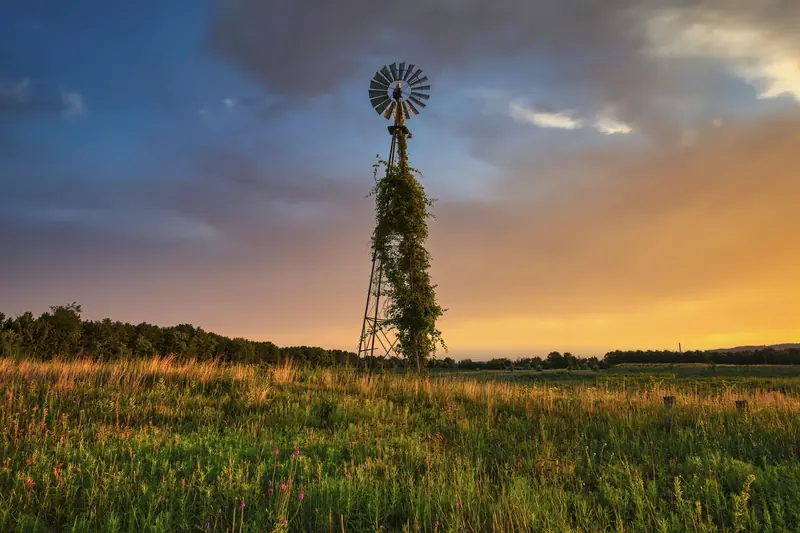 An old windmill on the prairie at sunset