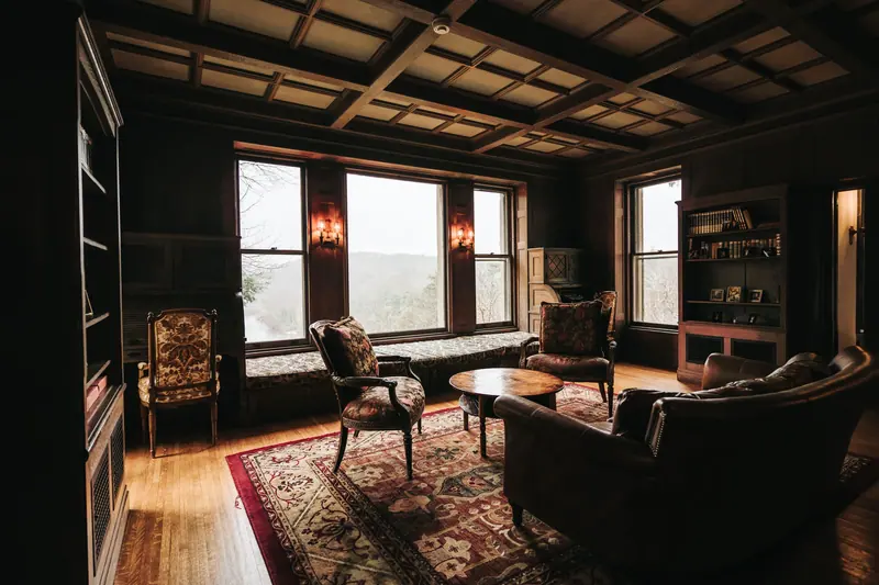 Warm and elegant vintage living room with armchairs and large windows.