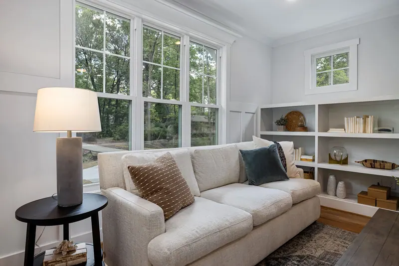 Inviting living room featuring a cozy sofa, large windows, and stylish decor.